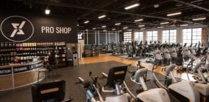 interior of qntm fit life with workout equipment and the pro shop station with supplements on shelves