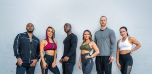 group of six qntm fit life personal trainers posing in from of a brick wall